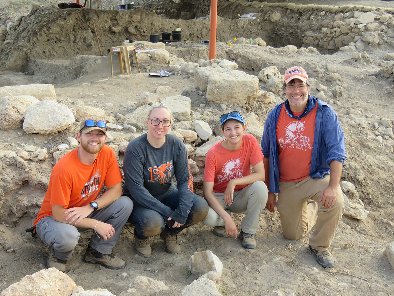 Nick Pumphrey with three Baker students at an excavation site.