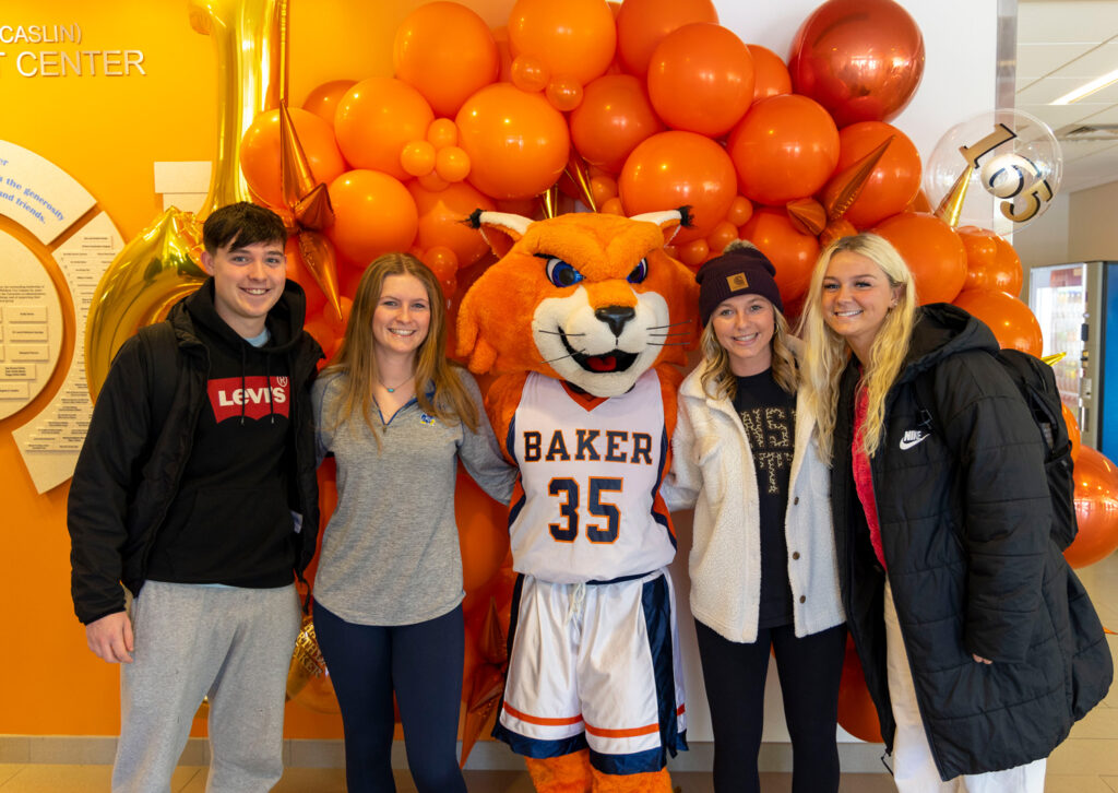 Baker students and WOWzer mascot at the Founders Day 165th birthday celebration balloon arch.