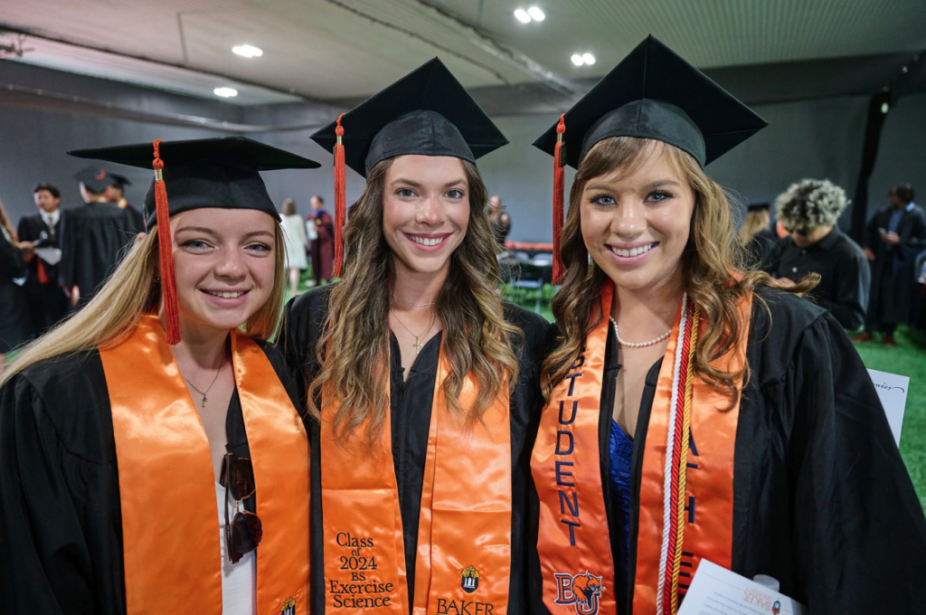 three grads pose for photo during commencement