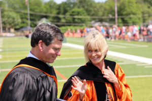 Frank Bisignano and Dr. Murray walking across the football field after commencement 2024